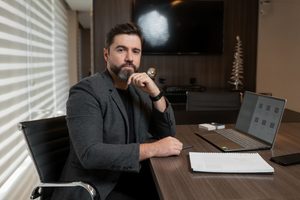 Rafael Martins, fundador da Salus Health Marketing, trabalhando em um notebook em seu escritório
