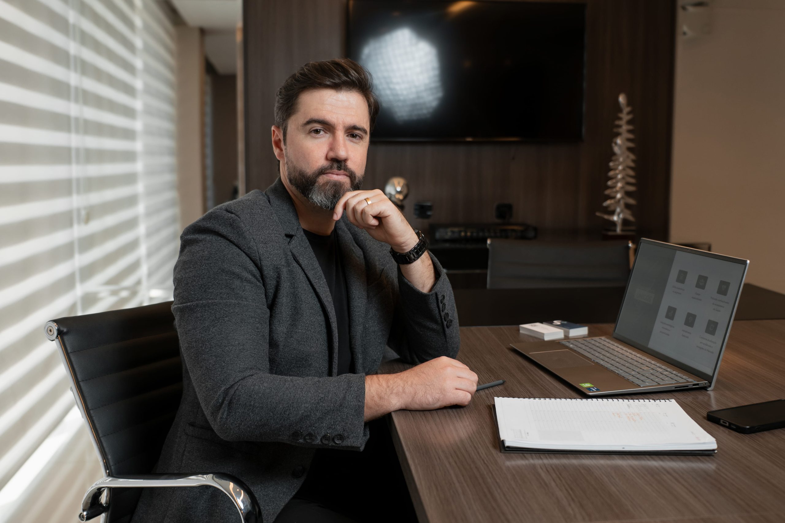 Rafael Martins, fundador da Salus Health Marketing, trabalhando em um notebook em seu escritório
